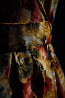 Doğal kumaştan yapılmış ve mankenin üzerindeki çiçek desenli bir elbise. Terzi evde özel terzilik yapıyor. Aydınlatıcı elbisenin güzel dikişleri yakın plan