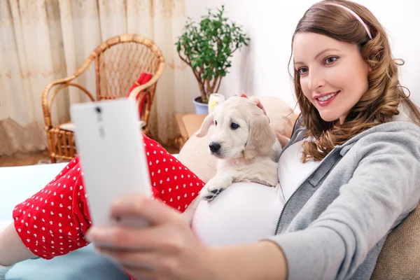 Pregnant woman with her dog at home — Stock Photo, Image