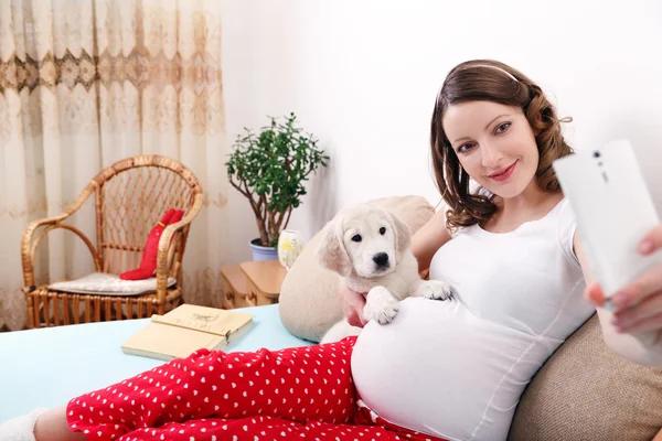 Mulher grávida com seu cão em casa — Fotografia de Stock