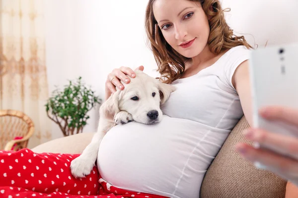 Mujer embarazada con su perro en casa — Foto de Stock