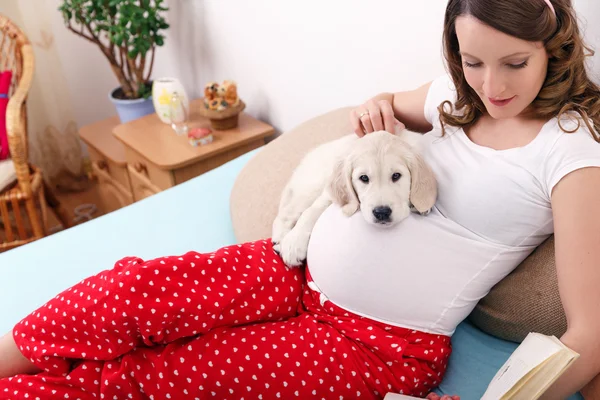 Mujer embarazada con su perro en casa — Foto de Stock