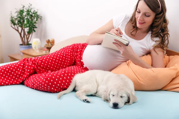 Donna incinta con il suo cane a casa — Foto Stock