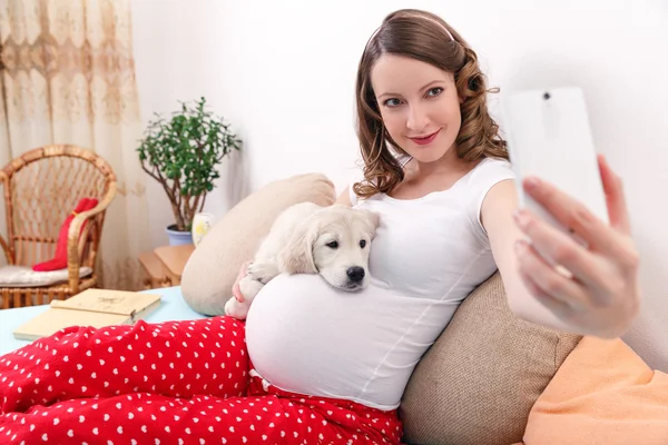 Mulher grávida com seu cão em casa — Fotografia de Stock