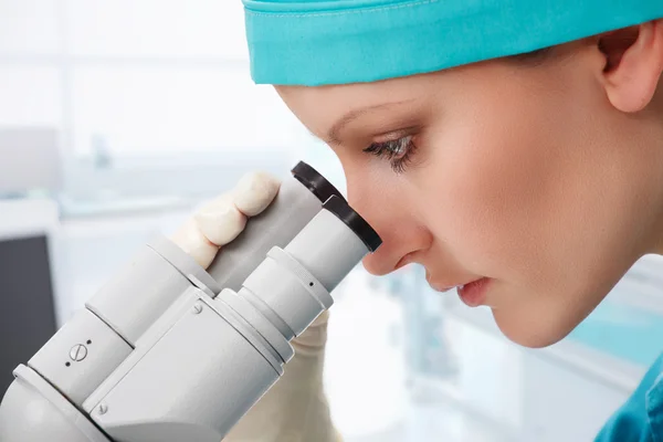 Mujer científica trabajando con microscopio — Foto de Stock