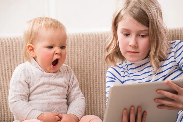 Two sisters watching tablet PC — Stock Photo, Image