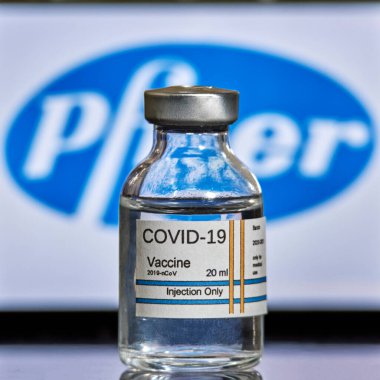 MALLORCA / İspanya - 13 Kasım 2020: Pfizer Biontech araştırma Coronavirus (Covid 19) aşısı. Arka planda bulanık Pfizer şirket logosu olan aşı şişeleri..