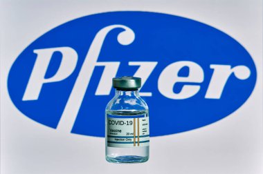 MALLORCA / İspanya - 13 Kasım 2020: Pfizer Biontech araştırma Coronavirus (Covid 19) aşısı. Arka planda bulanık Pfizer şirket logosu olan aşı şişeleri..