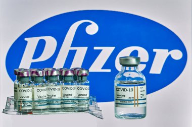 MALLORCA / İspanya - 13 Kasım 2020: Pfizer Biontech araştırma Coronavirus (Covid 19) aşısı. Arka planda bulanık Pfizer şirket logosu olan aşı şişeleri..