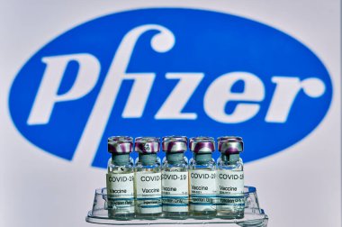 MALLORCA / İspanya - 13 Kasım 2020: Pfizer Biontech araştırma Coronavirus (Covid 19) aşısı. Arka planda bulanık Pfizer şirket logosu olan aşı şişeleri..