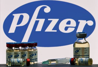 MALLORCA / SPAIN - 17 Kasım 2020: Pfizer Biontech araştırma Coronavirus (Covid 19) aşısı. Arka planda bulanık Pfizer şirket logosu olan aşı şişeleri..