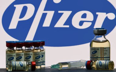 MALLORCA / SPAIN - 17 Kasım 2020: Pfizer Biontech araştırma Coronavirus (Covid 19) aşısı. Arka planda bulanık Pfizer şirket logosu olan aşı şişeleri..