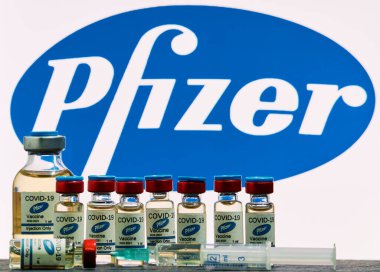 MALLORCA / SPAIN - 17 Kasım 2020: Pfizer Biontech araştırma Coronavirus (Covid 19) aşısı. Arka planda bulanık Pfizer şirket logosu olan aşı şişeleri..