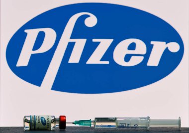 MALLORCA / SPAIN - 17 Kasım 2020: Pfizer Biontech araştırma Coronavirus (Covid 19) aşısı. Arka planda bulanık Pfizer şirket logosu olan aşı şişeleri..