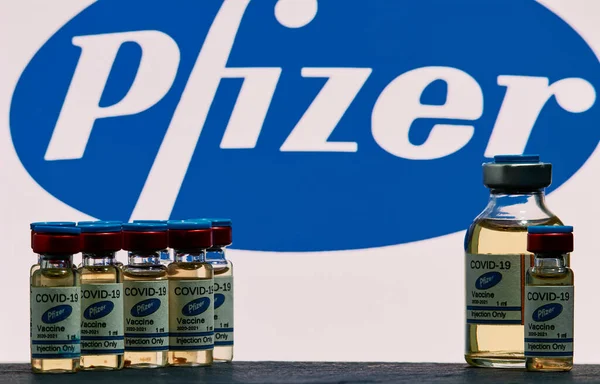 MALLORCA / SPAIN - 17 Kasım 2020: Pfizer Biontech araştırma Coronavirus (Covid 19) aşısı. Arka planda bulanık Pfizer şirket logosu olan aşı şişeleri..