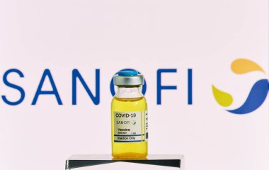 MALLORCA / SPAIN - 21 Kasım 2020: Sanofi araştırma Coronavirus (Covid 19) aşısı. Arka planda bulanık Sanofi şirketi logosu olan aşı şişeleri..