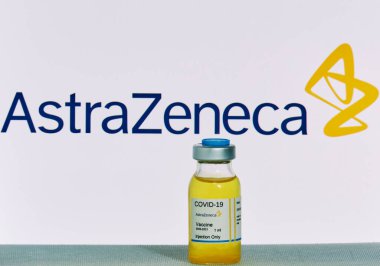 MALLORCA / SPAIN - 21 Kasım 2020: AstraZeneca araştırma Coronavirus (Covid 19) aşısı. Arka planda bulanık AstraZeneca şirketi logosu olan aşı şişeleri..