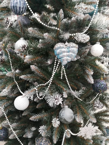 Snow-white branches of a christmas tree with christmas balls and garland — Stock Photo, Image