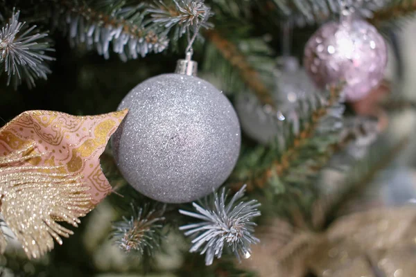 Julgran, bollar, dekorationer med dekorativa leksaker, rosetter och band med selektivt fokus — Stockfoto