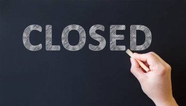 Kapalı - kara tahtaya yazılı metin. Tebeşirli el metin yazar