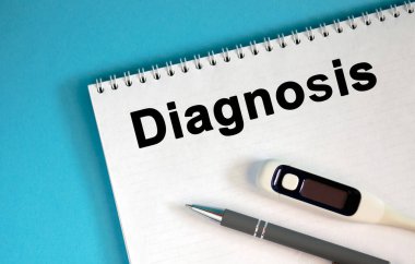 DiAGNOSIS - bir not defterinde metin. Bir kalem ve tıbbi termometre yalan söyle.