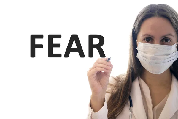 Ärztin in Maske hält Stift und schreibt Angsttext — Stockfoto