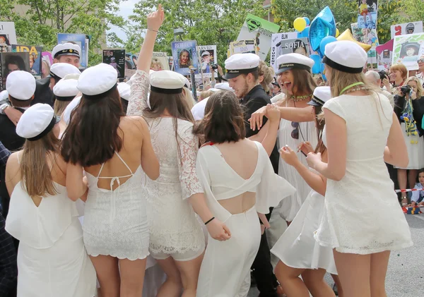 Happy teenagers wearing graduation caps celebrating the graduati