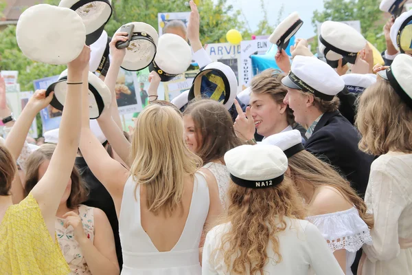 Heureux adolescents levant la casquette de graduation célébrant le gradu — Photo