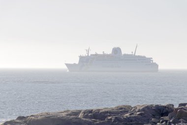 Grisslehamn, İsveç - Mar 28, 2016: Grisslehamn İskandinavya'da ilkbahar da güneşli bir günde sis, uçurumlar ve ağaçlarda gizlenmiş büyük feribot, Mars 28, 2016, Grisslehamn, İsveç