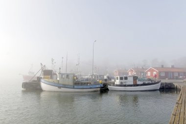 Grisslehamn İsveç - 01 Mayıs 2016: Sisli sabah Grisslehamn, İsveç'te bir limanda küçük balıkçı tekneleri