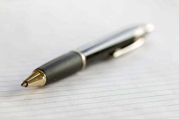 Closeup of a pencil on a striped writing pad. Very short depth of focus