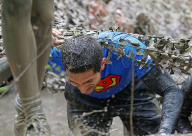Stockholm, İsveç - 14 Mayıs 2016: 14 Nisan 2016 'da İsveç' te Zorlu Viking Etkinliği 'nde kamuflaj ağı altında çamurla kaplı bir adam