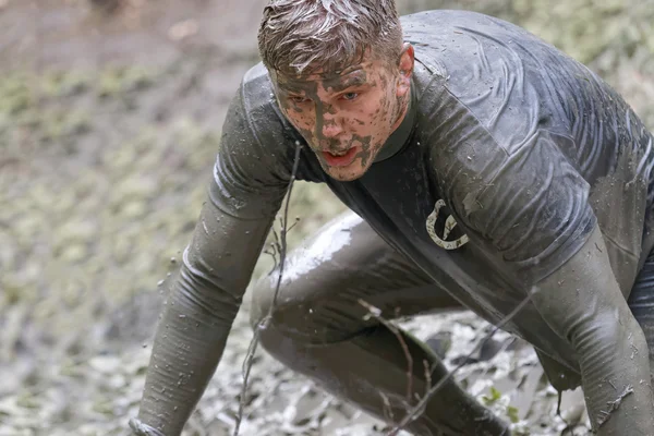 Man covered with mud crawling — Stock Photo, Image