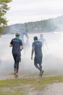 Grup throuh duman, çalışan adam içinde belgili tanımlık geçmiş bir göl