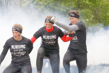 Stockholm, İsveç - 14 Mayıs 2016: 14 Nisan 2016 'da İsveç' te düzenlenen engelli yarışında yanan ve duman içinde koşan sarışın grup