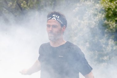 Stockholm, İsveç - 14 Mayıs 2016: 14 Nisan 2016 'da İsveç' te düzenlenen zorlu Viking yarışında duman arkasında koşan adam