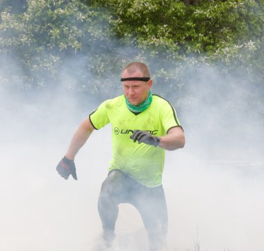 Ateş ve duman üzerindeki atlama sarı giysili adam