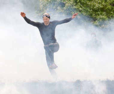 Stockholm, İsveç - 14 Mayıs 2016: Siyah elbiseli üstünden atlayarak erkeklerde ateş ve engel yarışta zor Viking olay İsveç ' te 14 Nisan 2016 duman