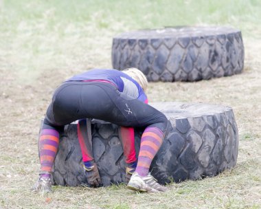 Stockholm, İsveç - 14 Mayıs 2016: Arkadan görünüş kadının büyük Traktör Lastiği engel engel yarışta zor Viking olay İsveç ' te 14 Nisan 2016 ipucu için mücadele
