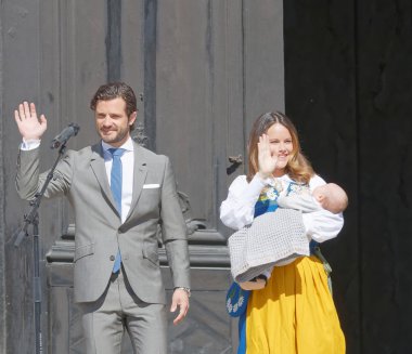 Stockholm, İsveç - Haziran 2016: İsveçli prens Carl Philip Bernadott ve prenses Sofia Hellqvist gülümseyip yeni doğan Alexander 'ı kucağında tutan seyircilere feragat ediyorlar