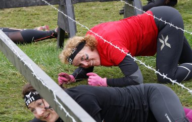 Stockholm, İsveç - 14 Mayıs 2016: İsveç 'te Zorlu Viking Etkinliği' nde dikenli tellerin altında sürünen kıdemli bir kadın