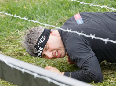 Stockholm, İsveç - 14 Mayıs 2016: 14 Mayıs 2016 'da İsveç' te Zorlu Viking Etkinliği 'nde dikenli tel altında sürünen adam