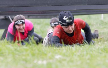 Stockholm, İsveç - 14 Mayıs 2016: 14 Mayıs 2016 'da İsveç' te düzenlenen zorlu Viking yarışında dikenli tellerin altında sürünen bir grup kadın