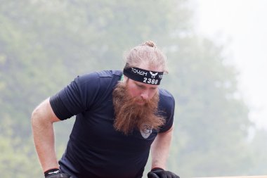 Büyük sakallı bir kapsayıcı engel tırmanma