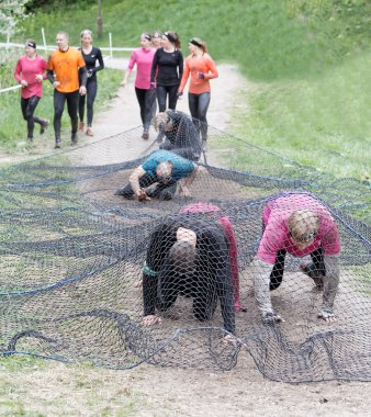 Stockholm, İsveç - 14 Mayıs 2016: Grup kadın gezinme altında net bir engel engel yarışta zor Viking olay İsveç, 14 Mayıs 2016