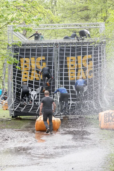 Stockholm, İsveç - 14 Mayıs 2016: 14 Mayıs 2016 'da İsveç' te düzenlenen zorlu Viking yarışında kadın ve erkekler net engele tırmanıyorlar.