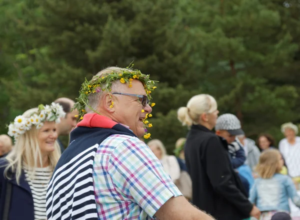 Sonriente hombre mayor con flores en el pelo bailando alrededor de la t — Foto de Stock