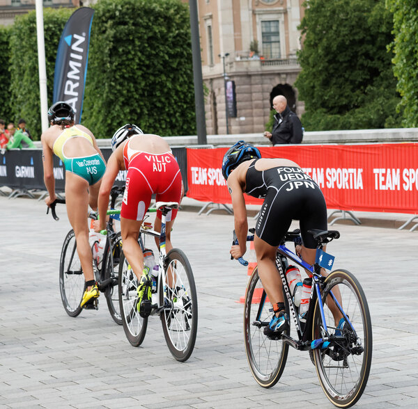 STOCKHOLM - JUL 02, 2016: Rear side view of  triathlete cyclists Ueda, Vilic and Van Coevorden in the Women's ITU World Triathlon series event July 02, 2016 in Stockholm, Sweden