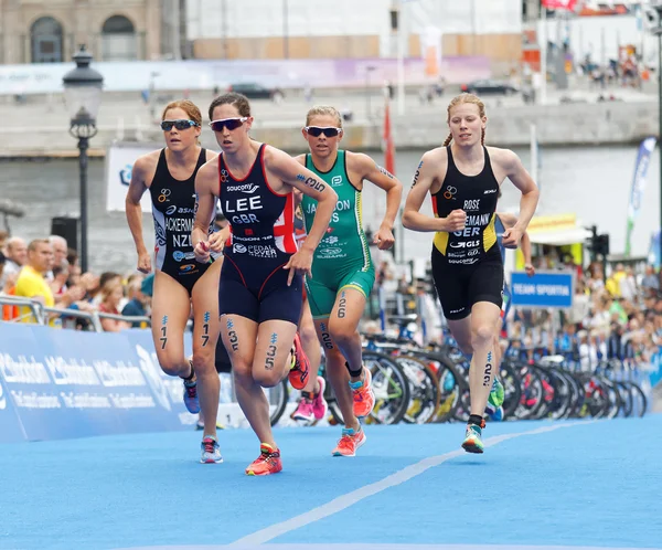 Group of colorful triathletes running in the transition zone — Stock Photo, Image