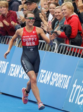 Triatlet kazanan Flora Son'u çalıştıran Duffy (Ber)