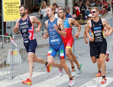 Bir eğrideki triathletes çalışan yan görünüm